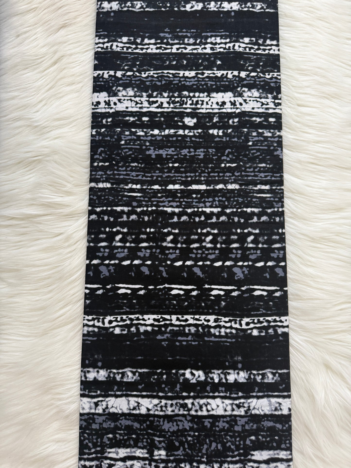 Black and white striped fabric on a white fur background
