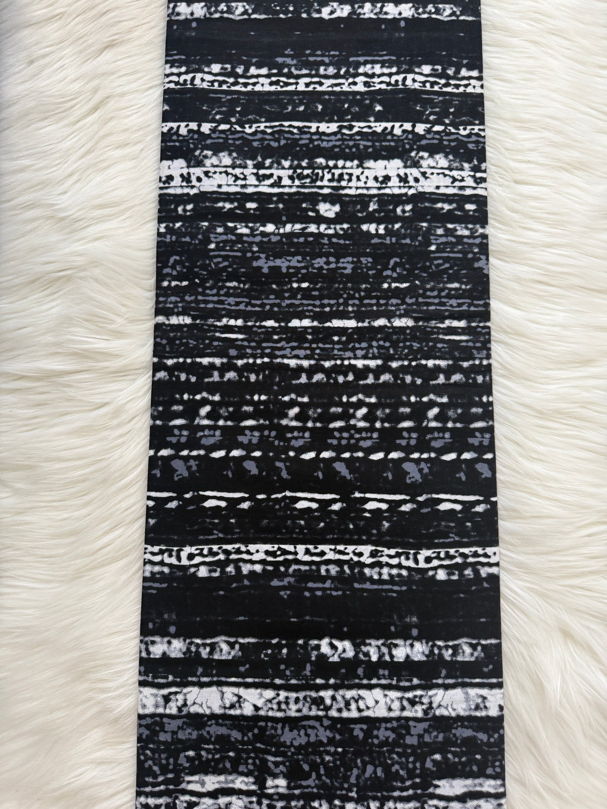 Black and white striped fabric on a white fur background