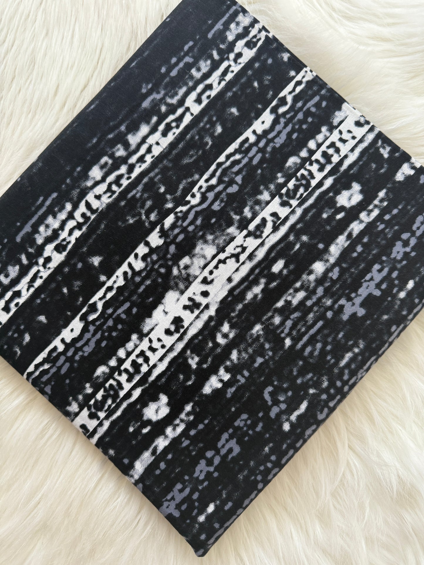 Black and white patterned fabric on a textured white surface