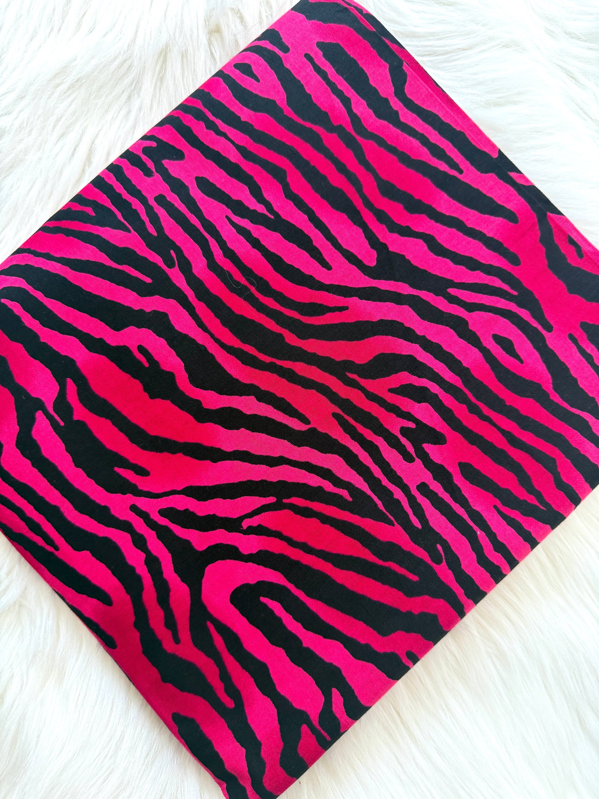 Pink and black zebra print fabric on a white background