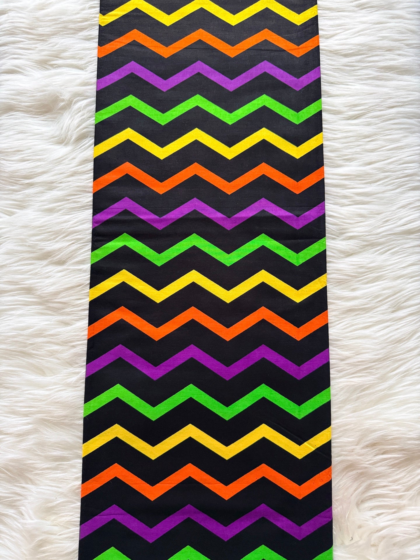 Colorful zigzag patterned fabric on a white textured background