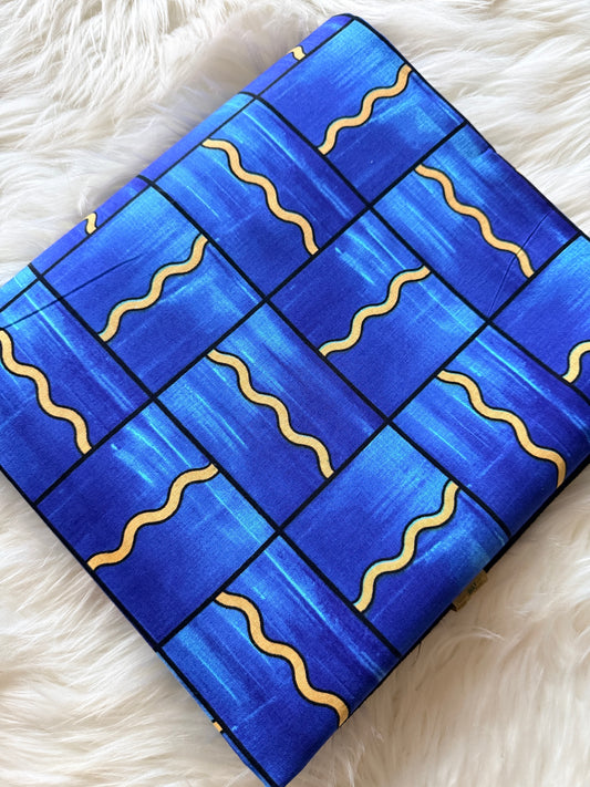 Blue rectangular object with wavy yellow lines on a white fluffy surface