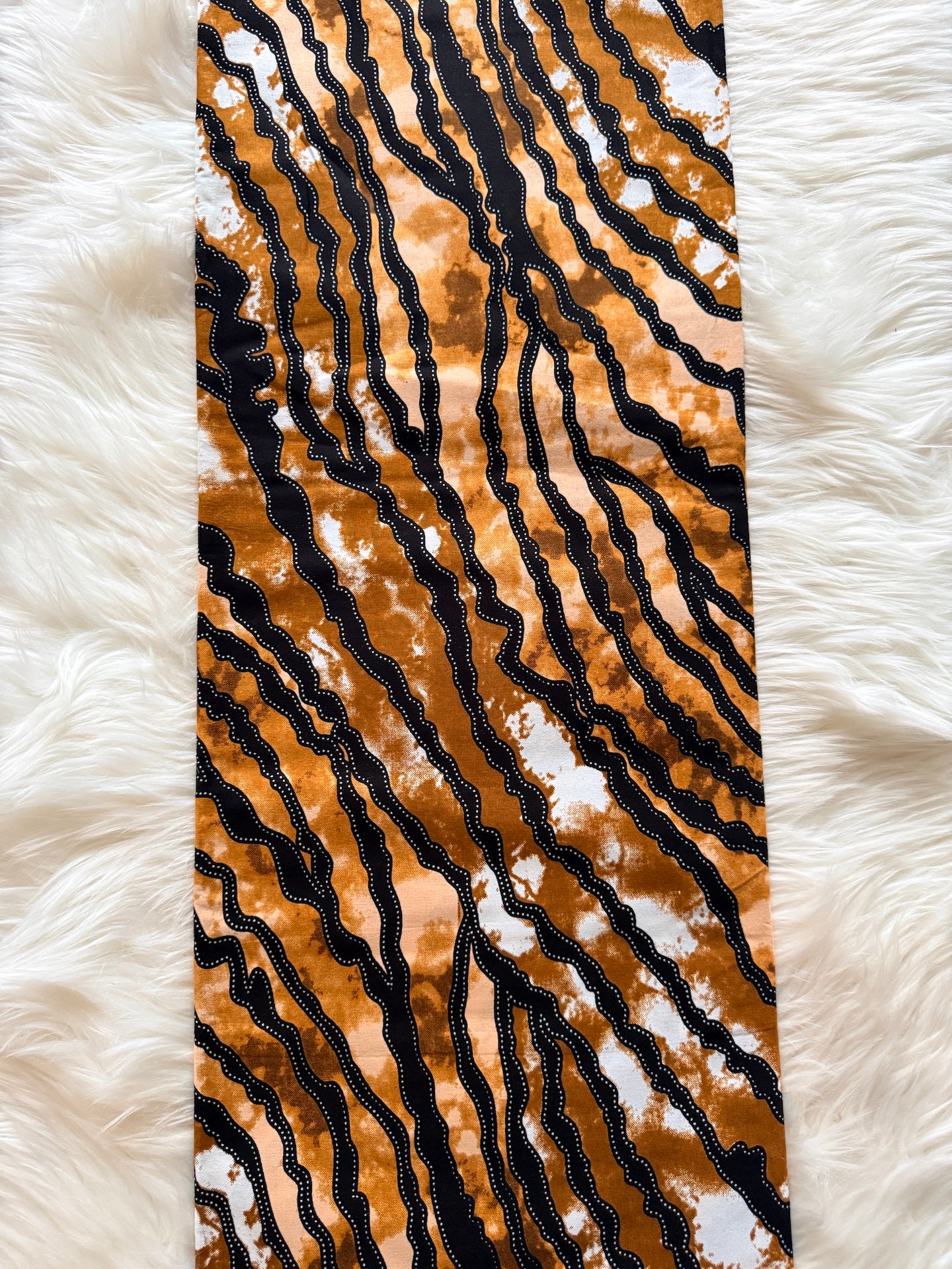 Tie with black and brown abstract pattern on a white fur background
