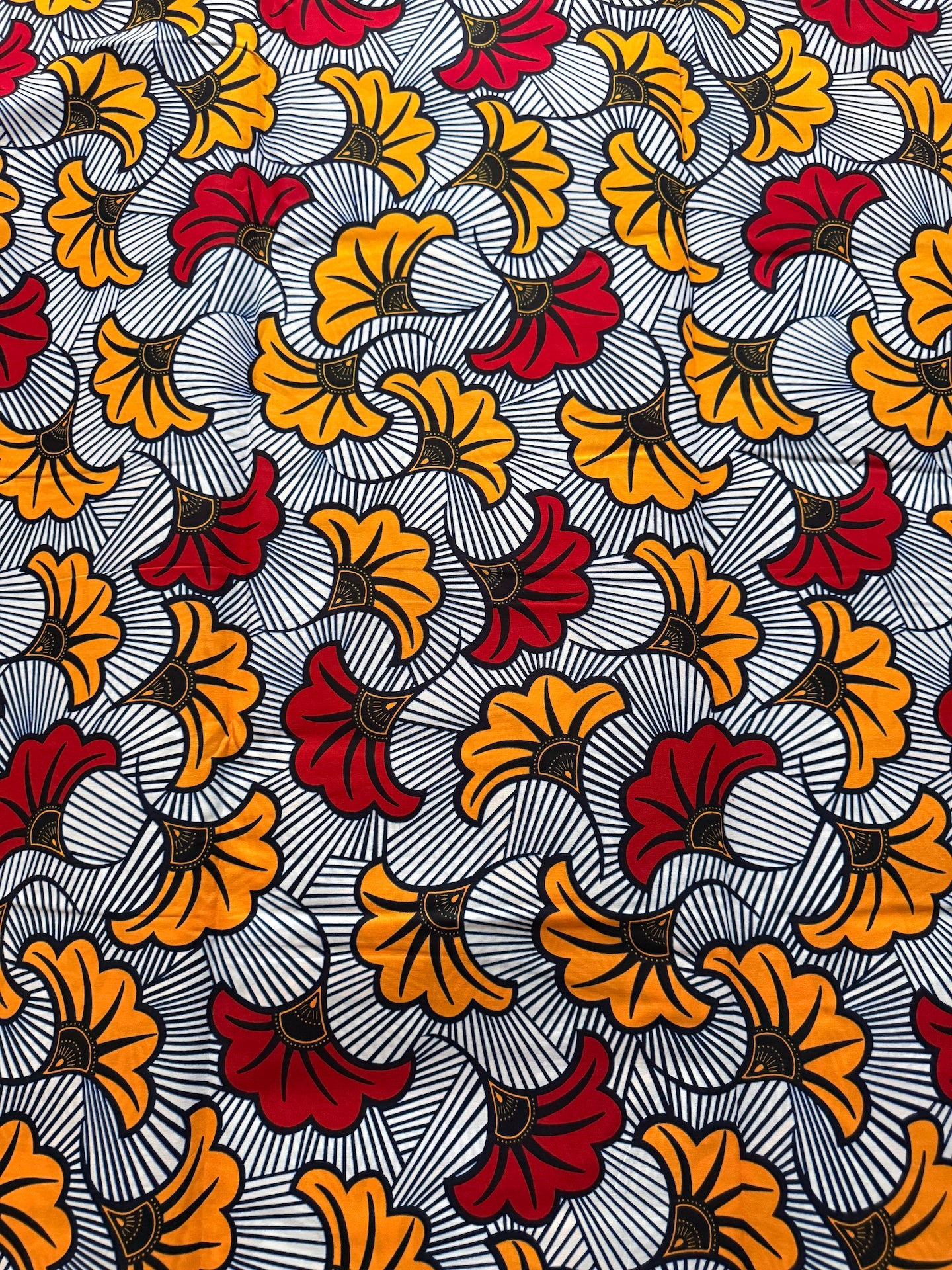 Patterned fabric with orange, red, and yellow flowers on a gray background