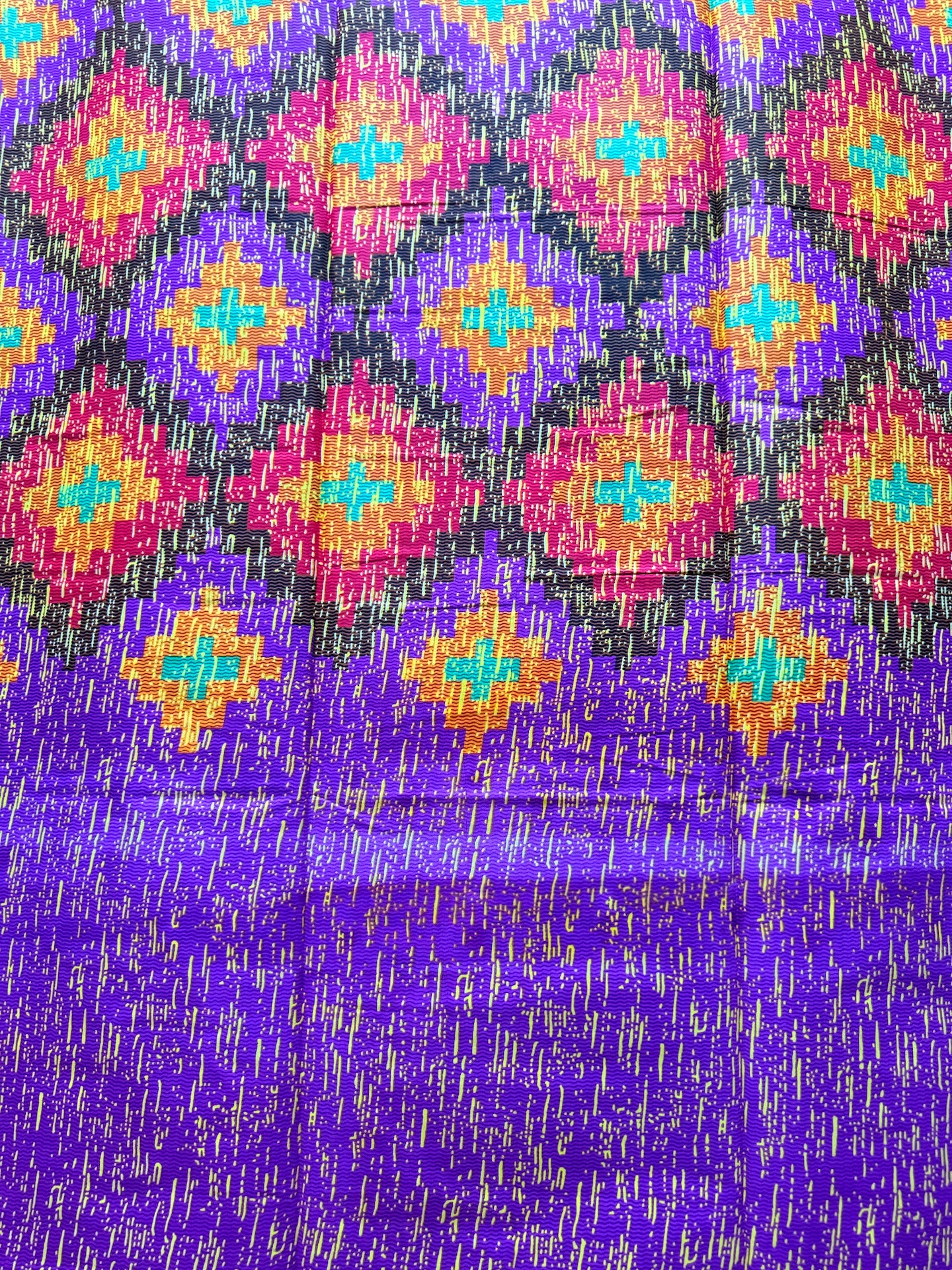 Colorful patterned fabric with geometric design on a purple background
