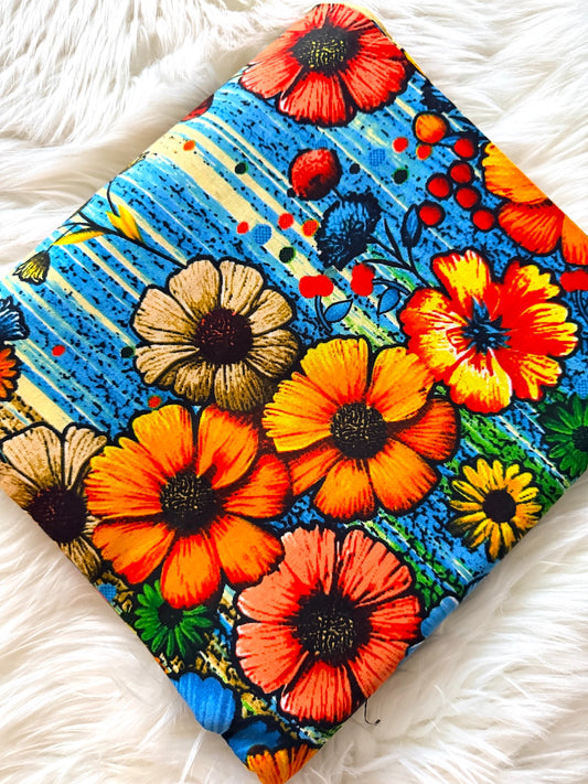 Colorful floral-patterned fabric on a white fluffy surface