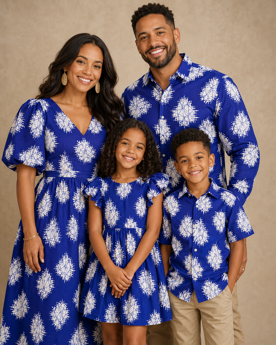 Family of four wearing matching blue and white floral outfits against a beige background